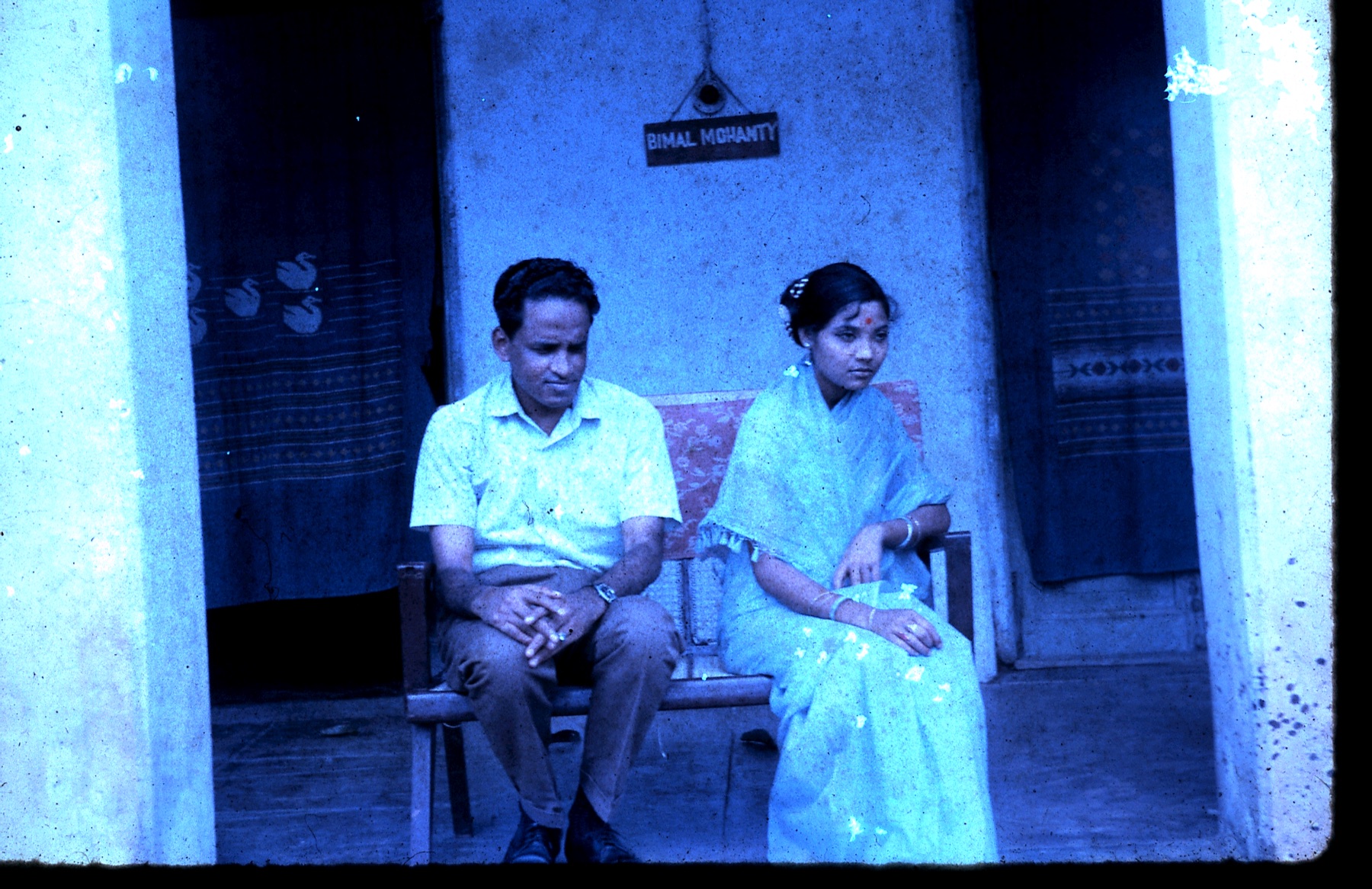 A young Gokulananda and Neena Das seated together on a bench