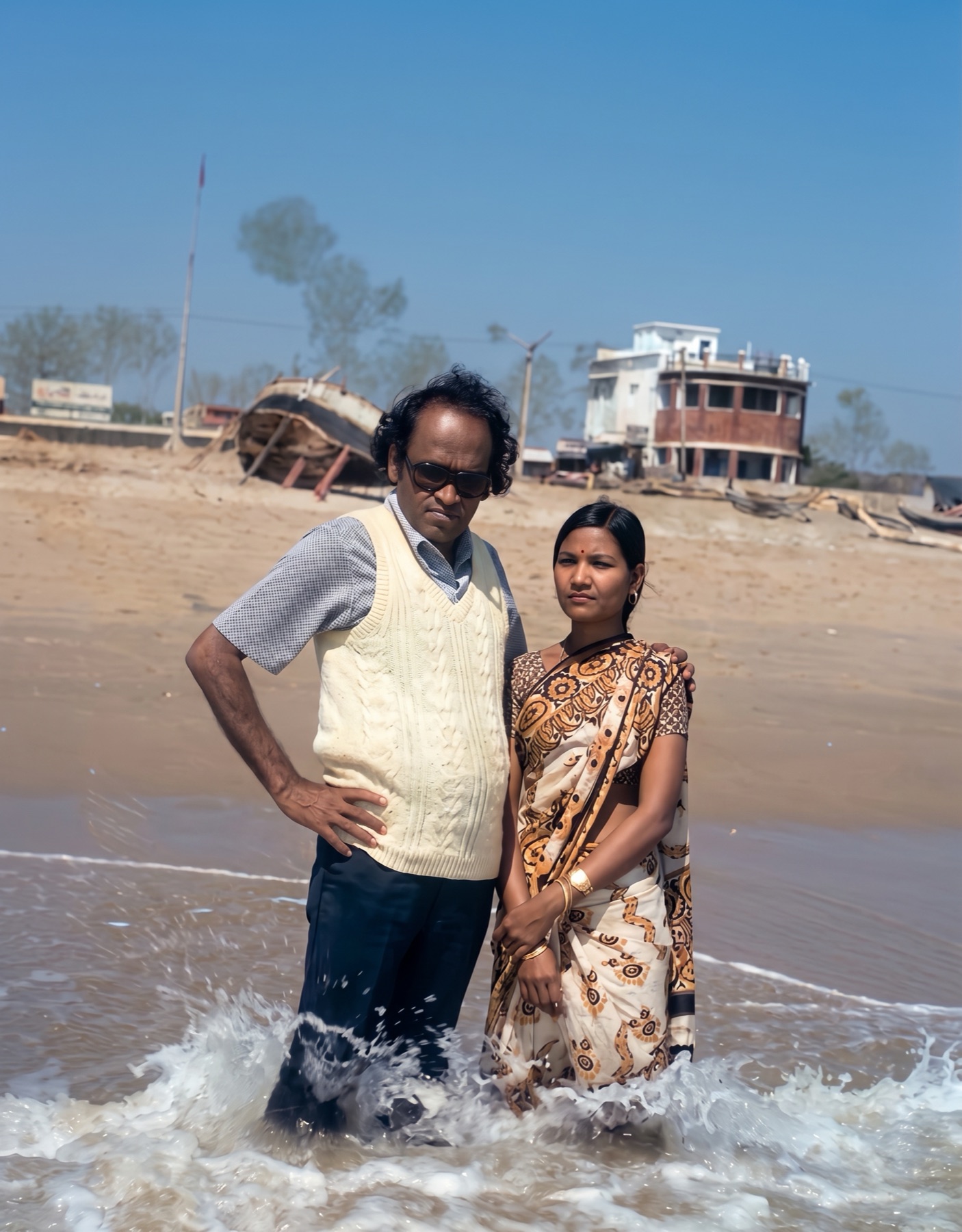 Dr. Das and Mrs. Neena Das standing in the surf at a beach in Odisha