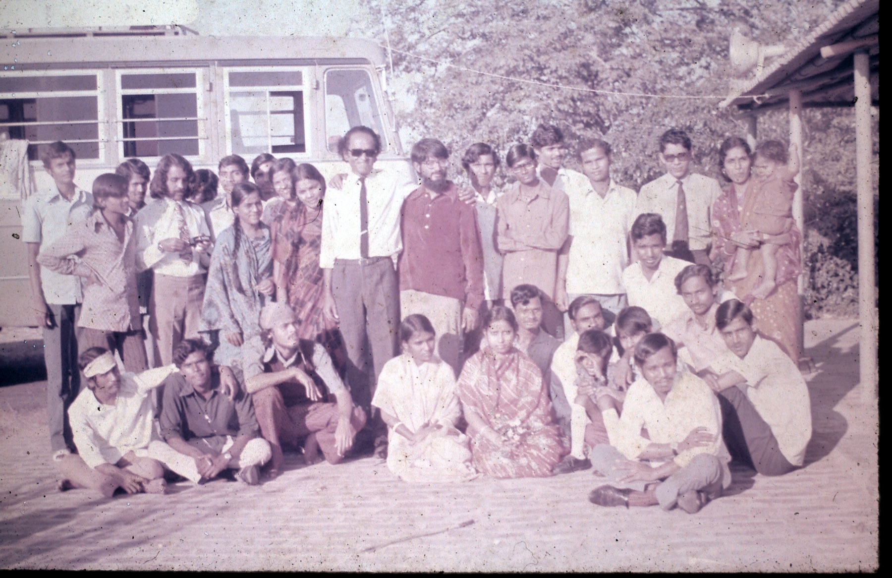 Dr. Das with a large group of students beside a bus on an excursion